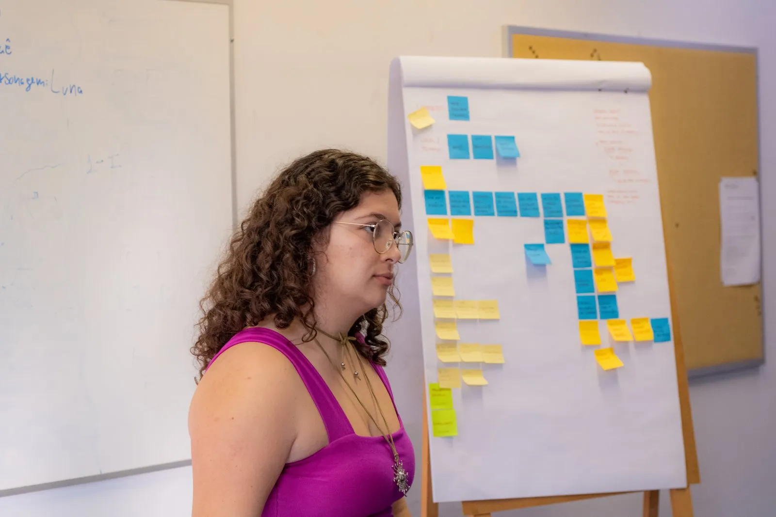 Uma participante ao lado de um flipchart cheio de post-its.