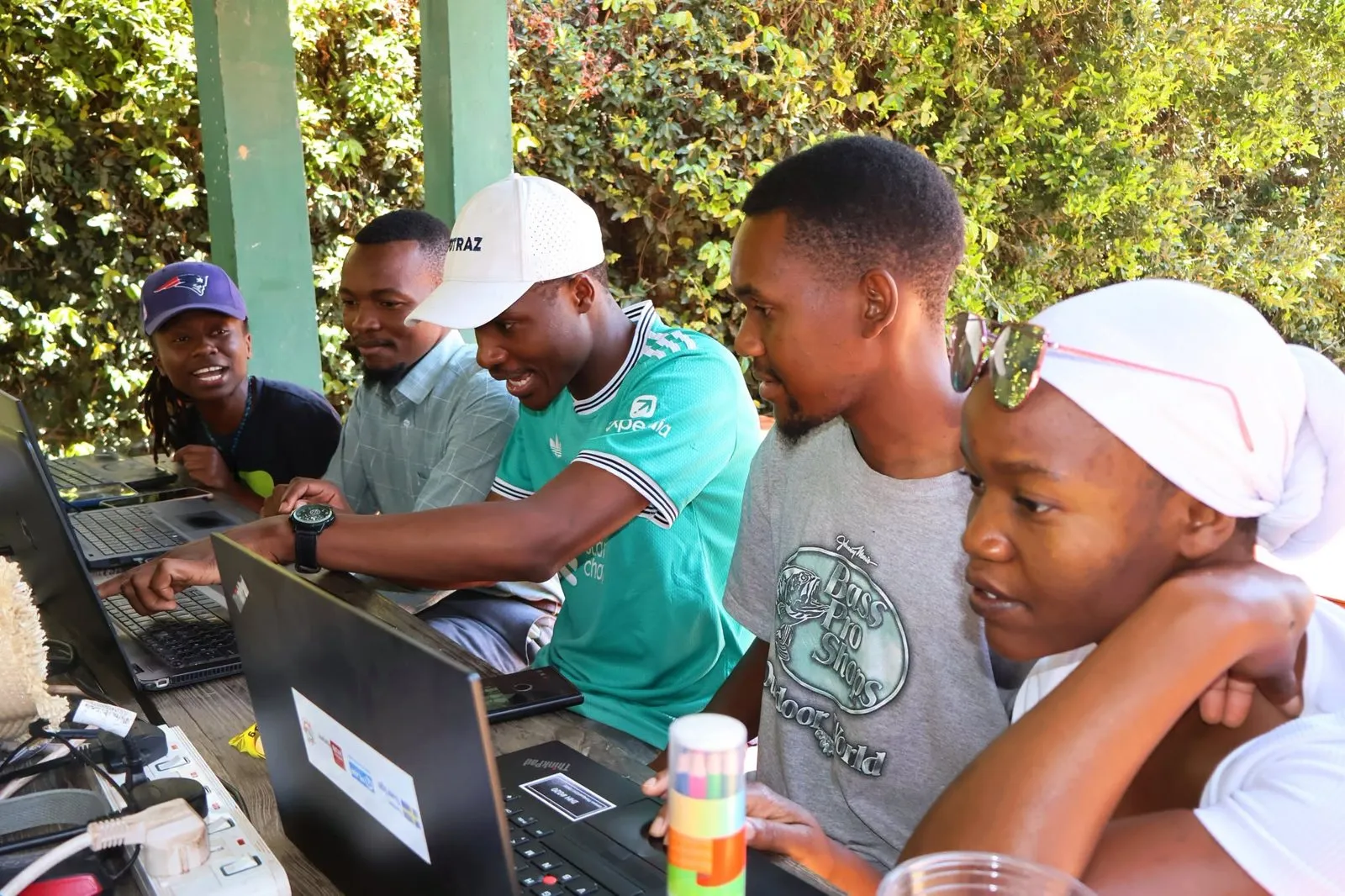 Um time trabalha junto em notebooks no Impact Hub Harare.